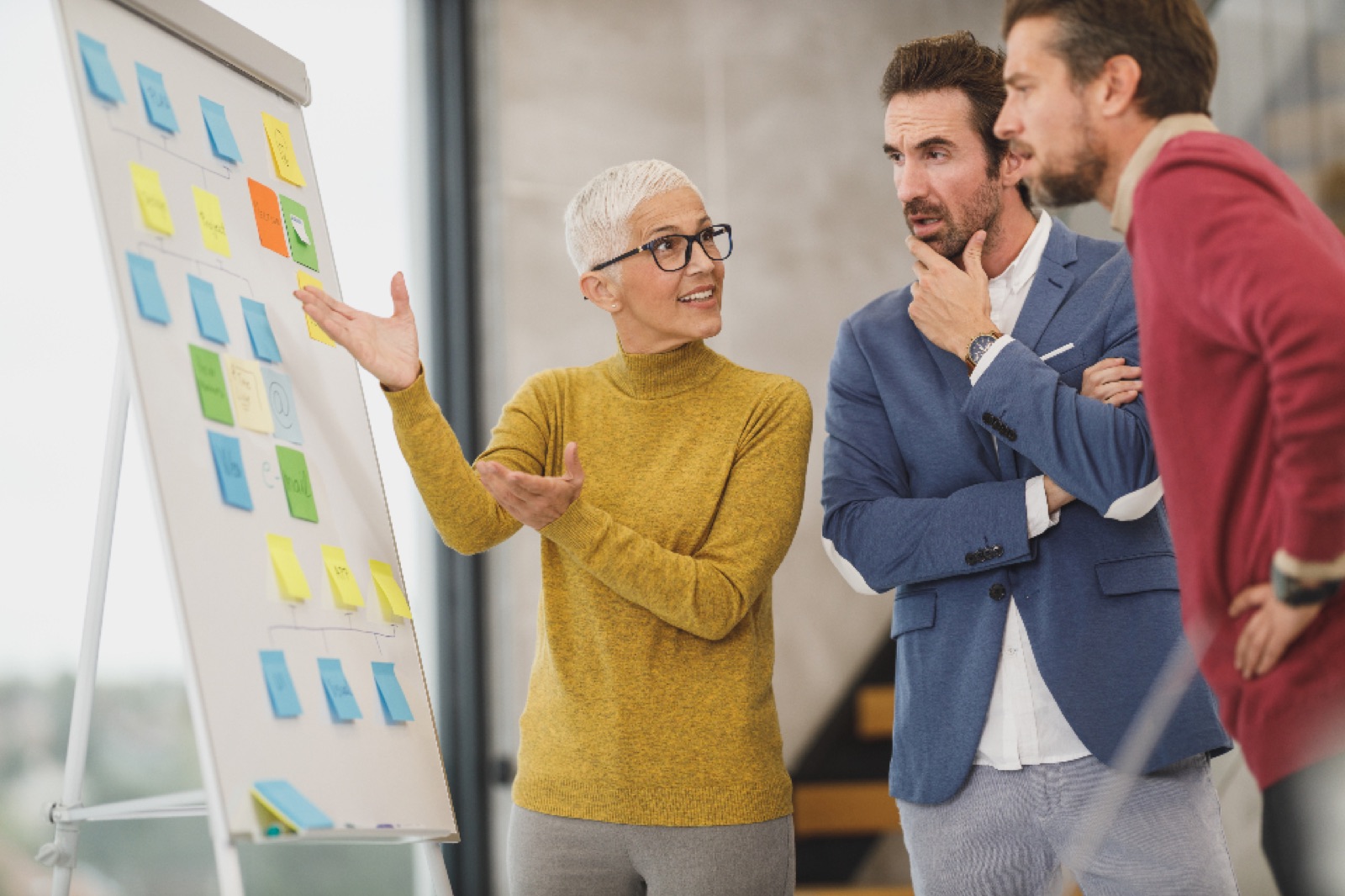 Team planning a project at a whiteboard covered in sticky notes