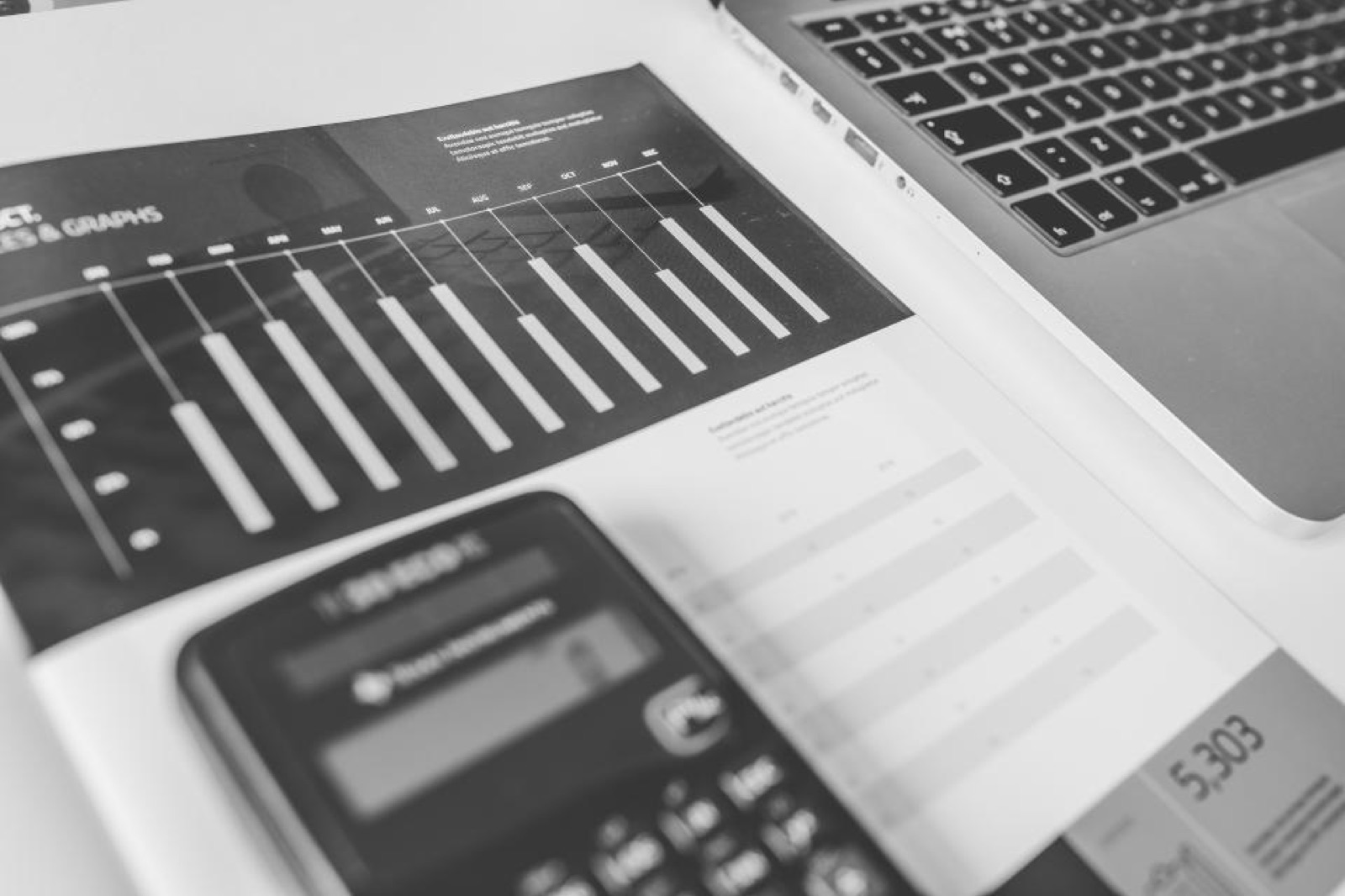 Calculator, laptop and budget charts on a desk