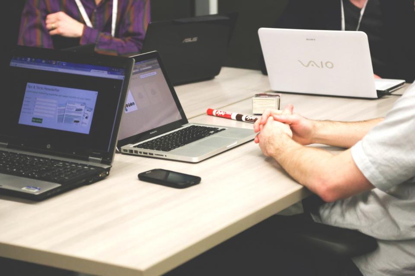 Colleagues collaborating at a table with laptops