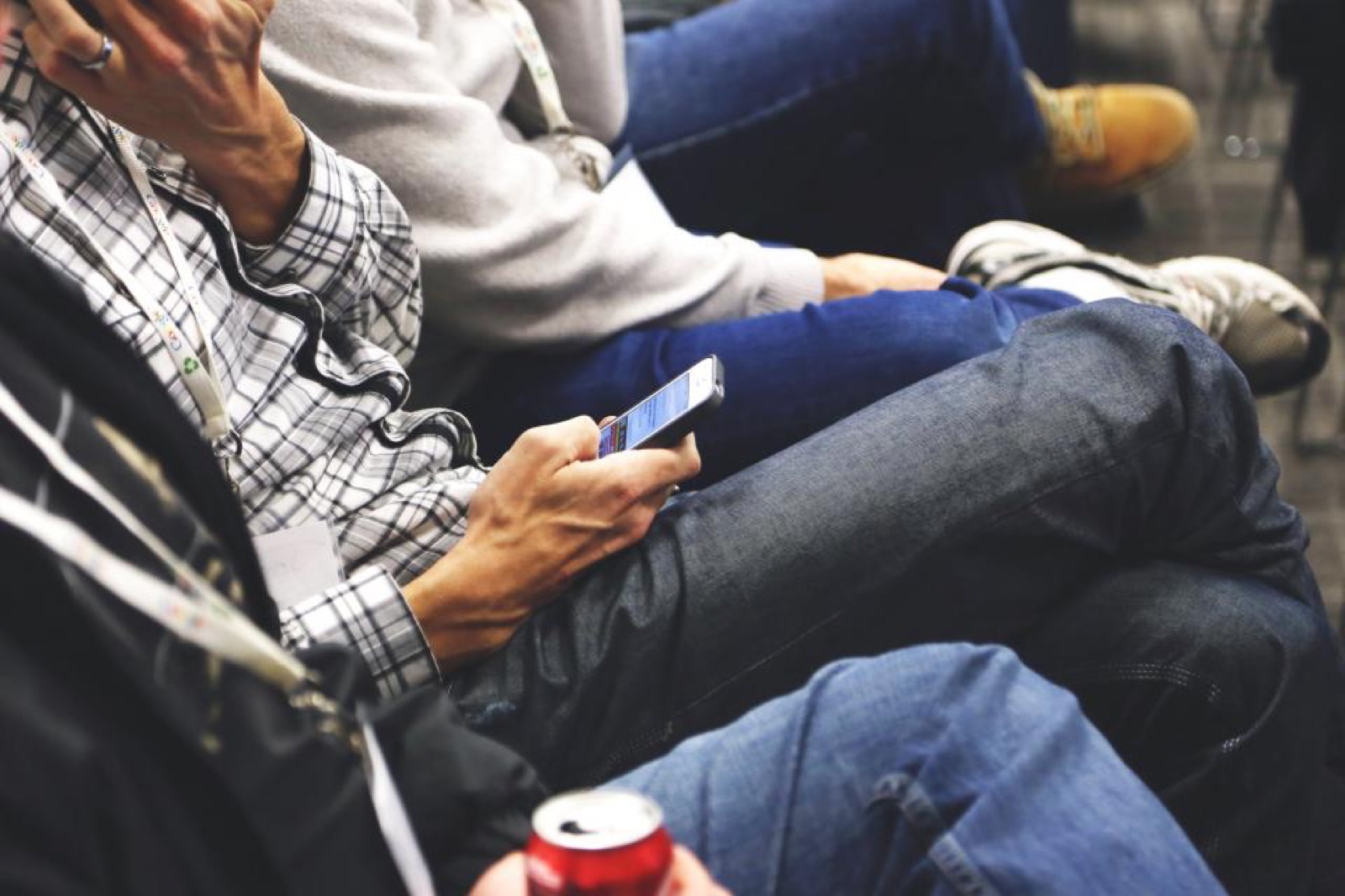 Business people seated in a row using smartphones and laptops