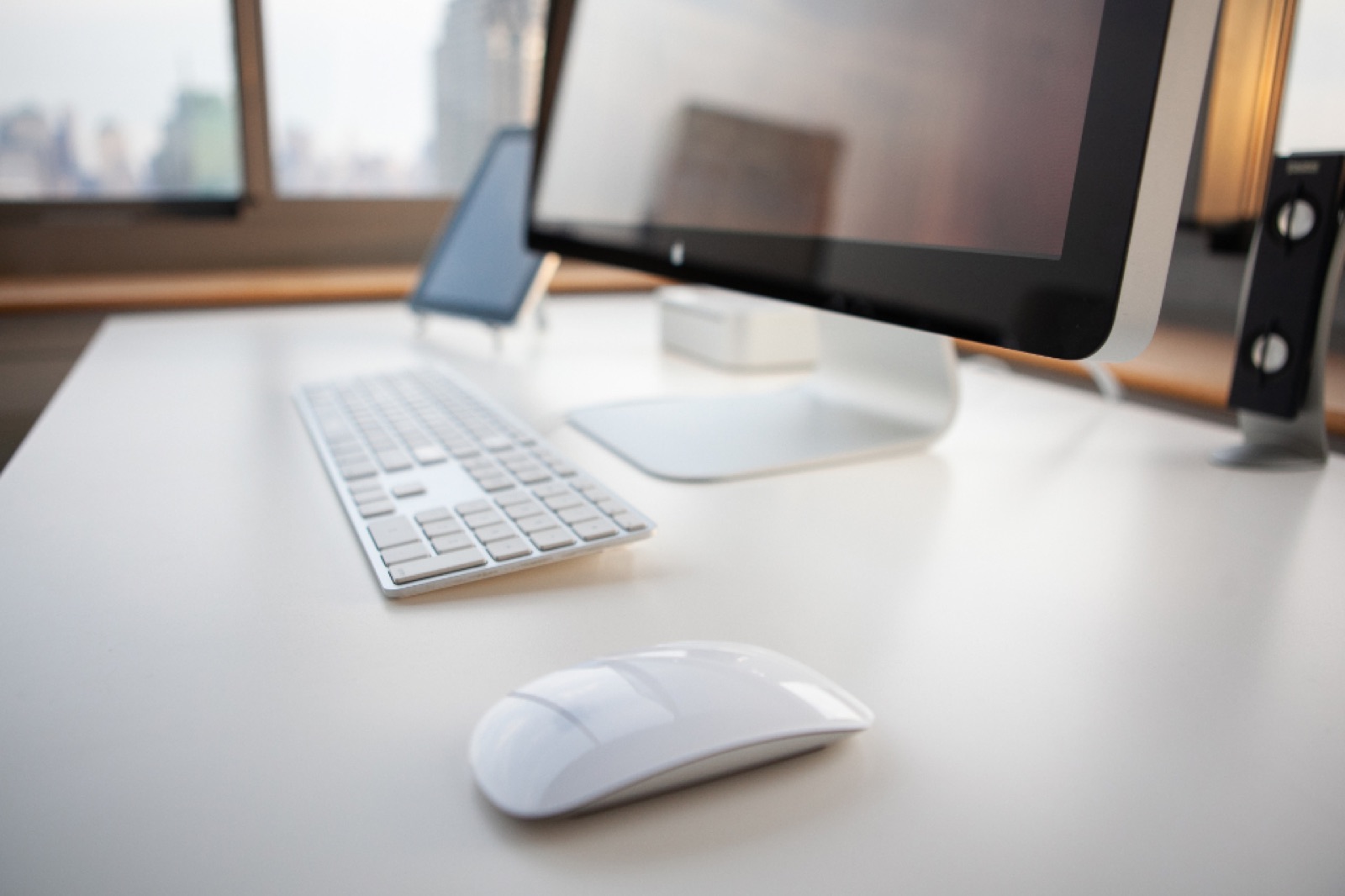 Clean home-office desk with a monitor, keyboard and mouse