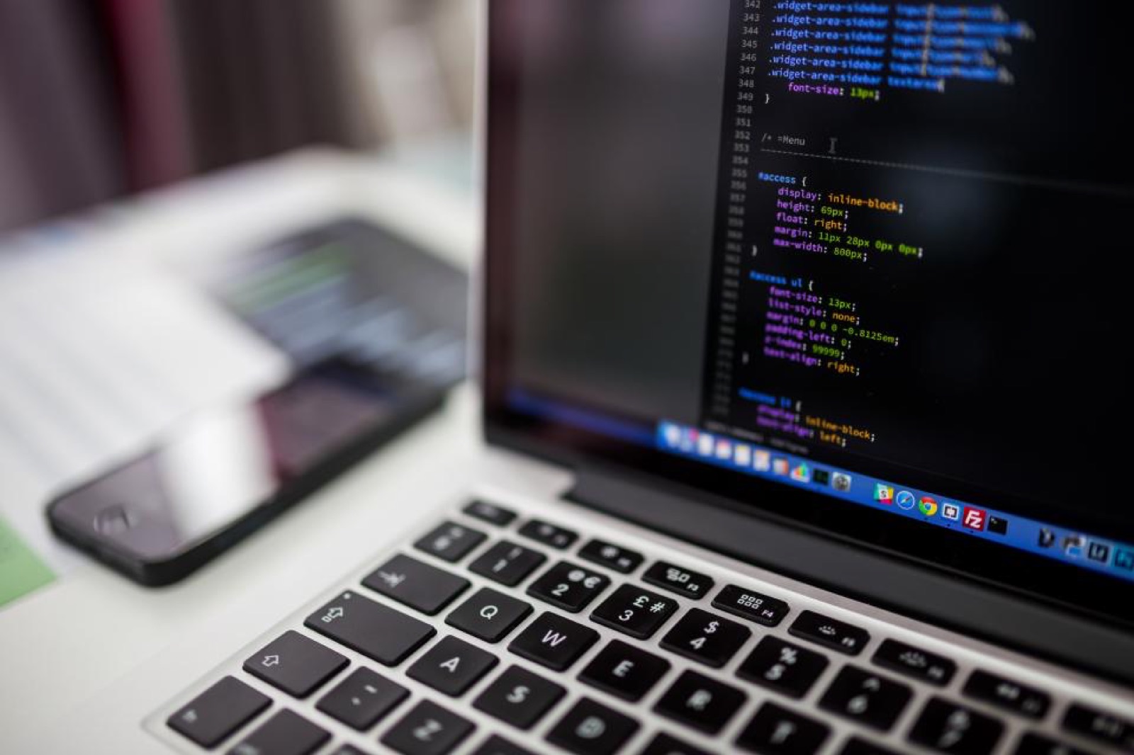 Laptop and monitor displaying code in a developer workspace