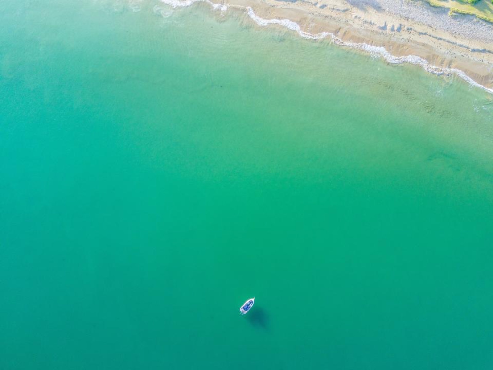 Aerial view of turquoise sea along a sandy coast